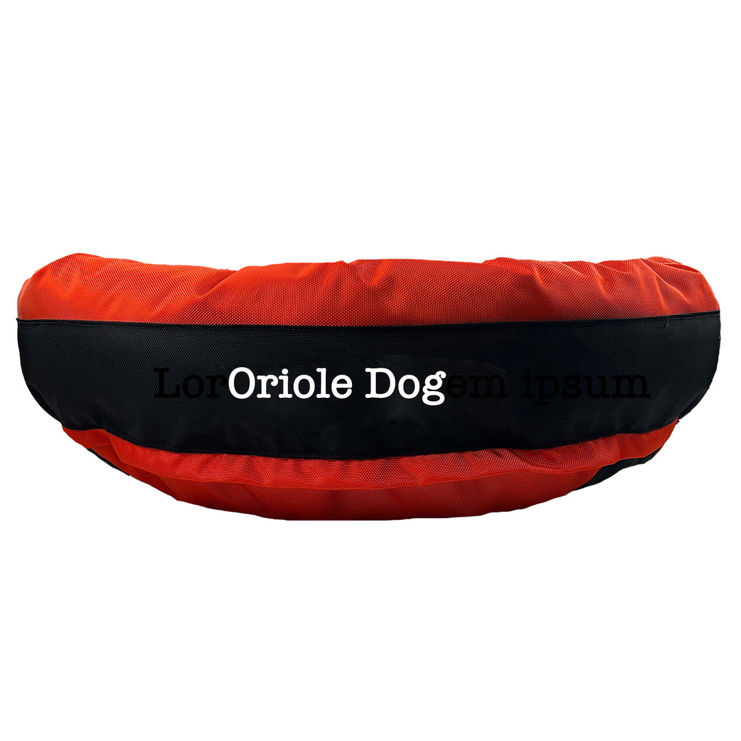 Orange round bolstered dog bed with black band and white embroidered 'Oriole Dog'.