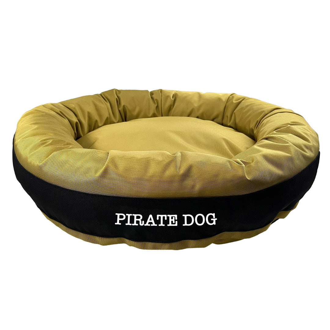 Gold round bolstered dog bed with a black band and white embroidered 'Pirate Dog'.