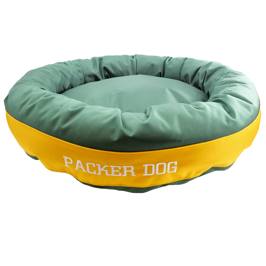 Green round bolstered dog bed with gold band and white embroidered 'Packer Dog'.