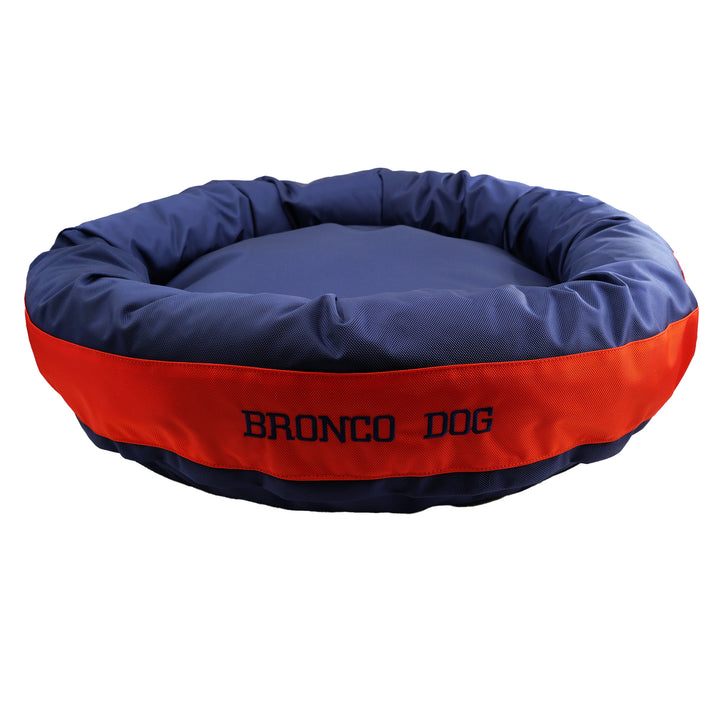 Blue round bolstered dog bed with an orange band with Navy embroidered 'Bronco Dog'.